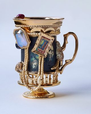 黒地にオパール調の大きな宝石と額絵、金の鎖を付けた脚付きの器