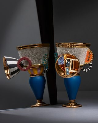 青い壺形の脚と金の縄模様の足に、白くきらめく粒の帯のカップをのせた器。鏡に反対側の面が映る