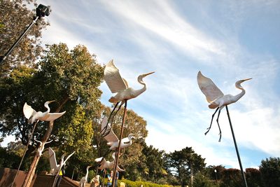 青空に向かって飛び立つ、白い鷺の彫刻群